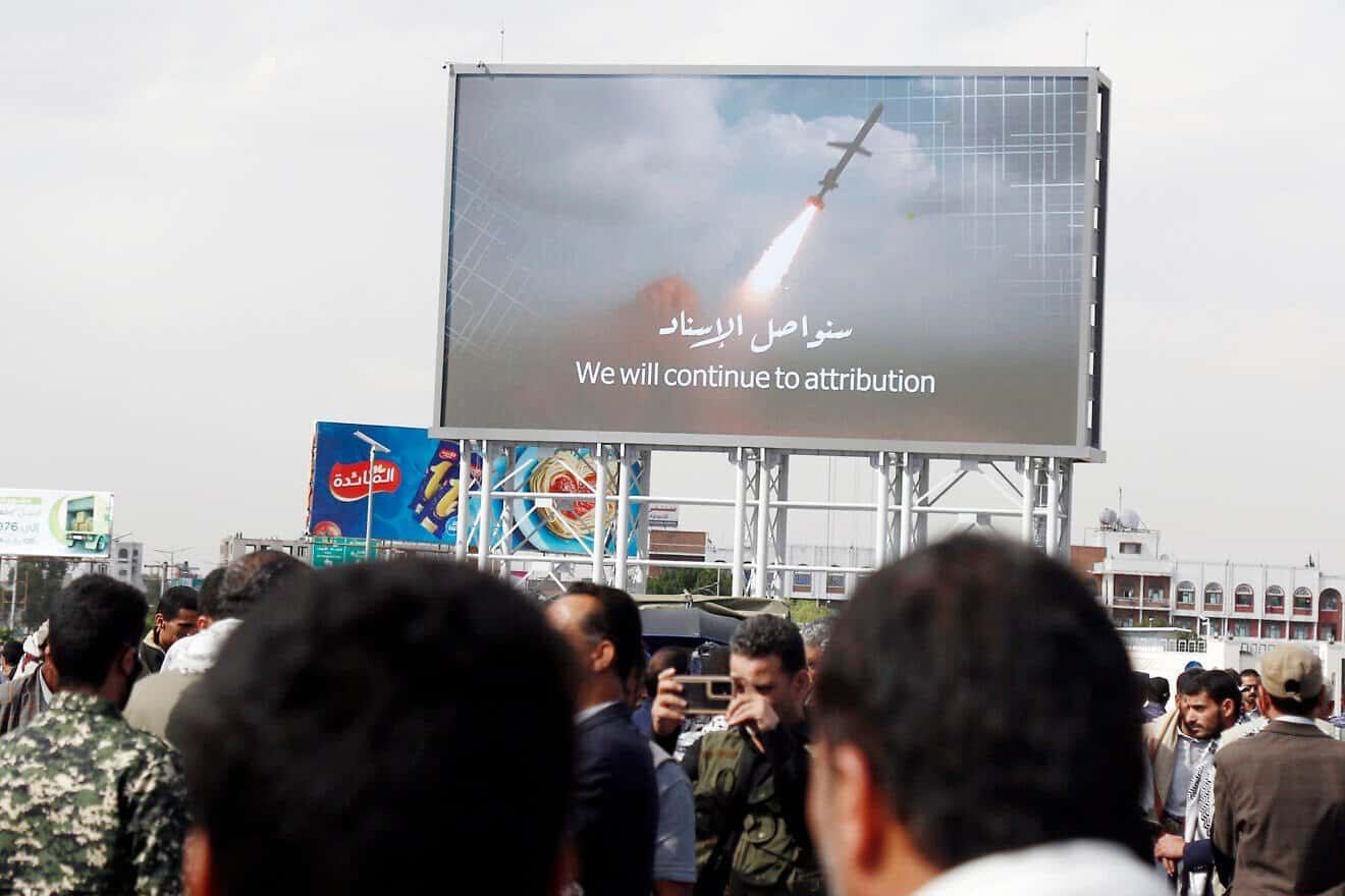 Yemenis walk under a large screen broadcasting the launch of a missile during a demonstration in Sanaa against the United States' aerial attacks on the city and other Yemeni provinces, March 17, 2025. Photo by Mohammed Hamoud/Getty Images.