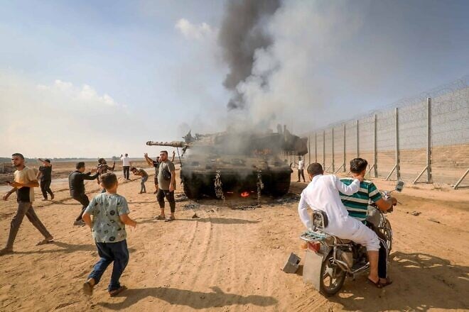 Palestinians take control of an Israeli tank after breeching the border fence from Khan Yunis in the southern Gaza Strip, Oct. 7, 2023. Photo by Abed Rahim Khatib/Flash90.