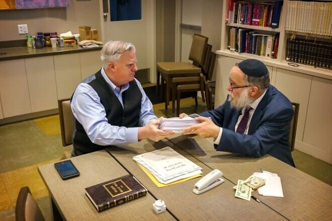 Rabbi Yosef Landa, the director of Chabad of Greater St. Louis, sells chametz ahead of Passover to Scott Biondo, the head of security for the Jewish Federation of St. Louis, in 2023. Credit: Chabad.