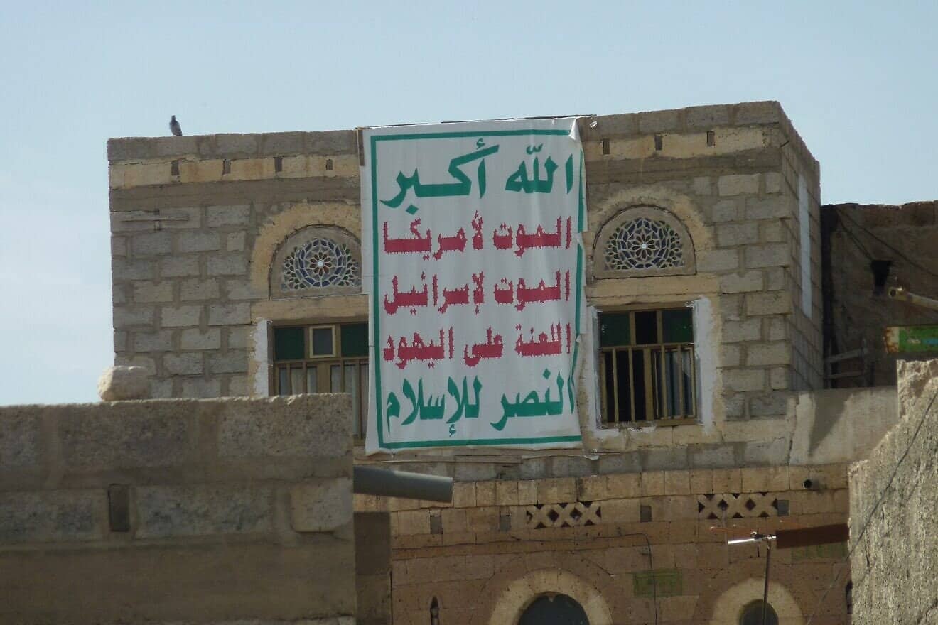 A banner with the "Sarkha," translated as "God is the Greatest, Death to America, Death to Israel, Curse be upon the Jews, Victory to Islam," the political slogan of the Houthis, on a house in Dhamar, Yemen, Sept. 26, 2013. Credit: Abdullah Sarhan via Wikimedia Commons.