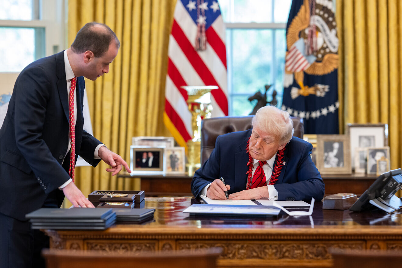 U.S. President Donald Trump signs executive orders alongside White House staff secretary Will Scharf in the Oval Office, April 17, 2025, in the Oval Office. Credit: Molly Riley/White House.