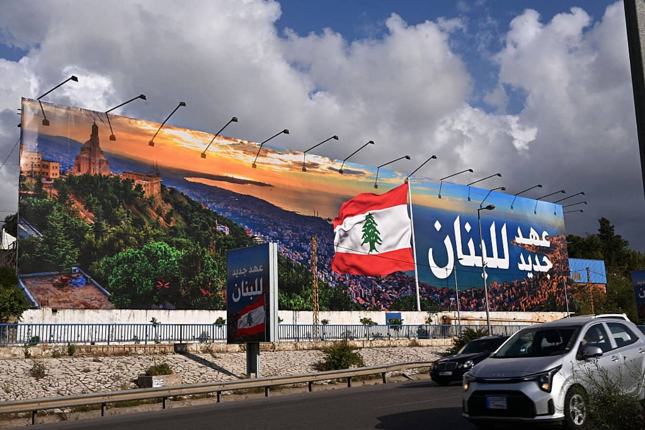 Commuters drive past a newly installed billboard bearing the image of a Lebanese flag and a statement that reads in Arabic "Lebanon a new era," replacing a Hezbollah billboard, on the road leading to Beirut's Rafic Hariri International Airport on April 10, 2025. Photo by Joseph Eid/AFP via Getty Images.