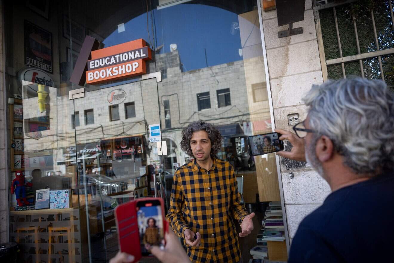Ahmad Muna standing outside his family's bookshop in eastern Jerusalem, after it was closed by the police for a second time, March 11, 2025. Photo by Chaim Goldberg/Flash90.