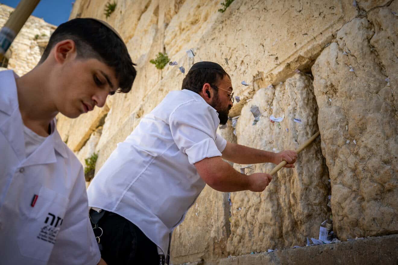 Workers remove handwritten notes placed between the ancient stones of the Western Wall in the Old City of Jerusalem, April 2, 2025. Photo by Yonatan Sindel/Flash90.