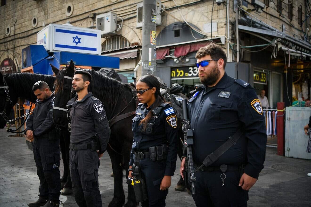 People stand still in outside the Mahane Yehuda Market in Jerusalem, as a two-minute siren is sounded across Israel to mark Holocaust Remembrance Day on April 24, 2025. Photo by Arie Leib Abrams/Flash90.