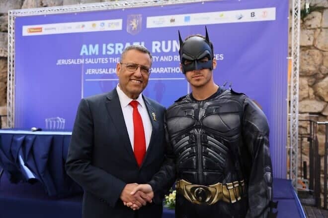 Jerusalem Mayor Moshe Lion and U.K.-based marathon runner Yoel Levy, who is running the Jerusalem Marathon in a Batman costume in memory of the Bibas children, who were hostages slain by Hamas in the Gaza Strip, April 3, 2025. Photo by Arnon Bossani.
