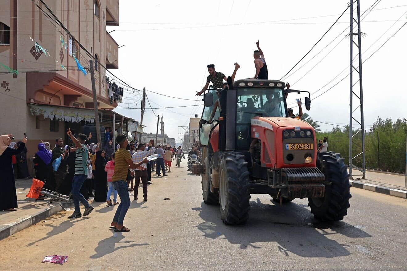 Palestinians drive an Israeli tractor that was seized after crossing the border fence with Israel from Khan Yunis in the southern Gaza Strip on Oct. 7, 2023. Photo by Said Khatib/AFP via Getty Images.