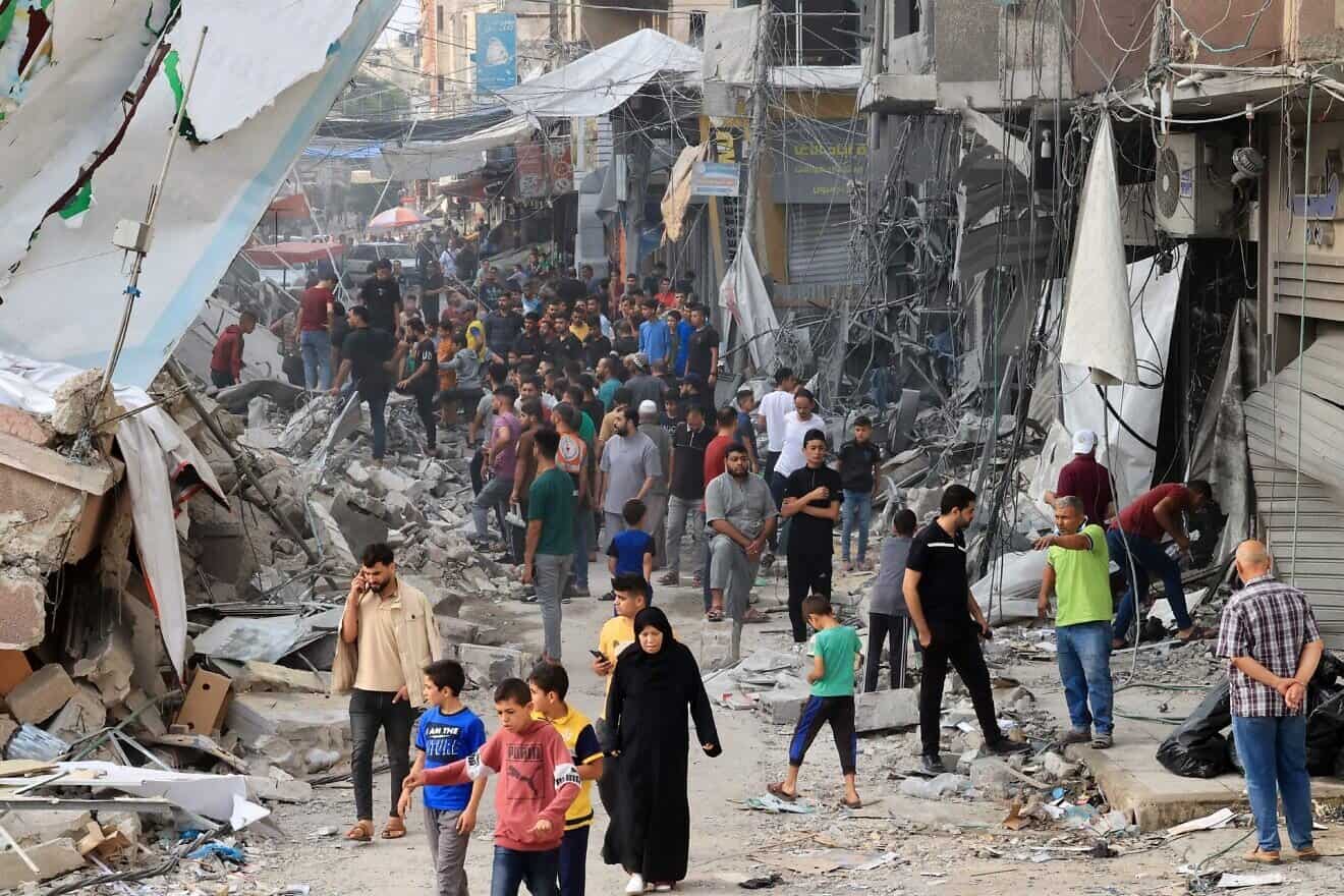 Palestinians walk amid the rubble of destroyed and damaged building in the heavily bombarded city center of Khan Yunis in the southern Gaza Strip, Oct. 10, 2023. Photo by Said Khatib/AFP via Getty Images.