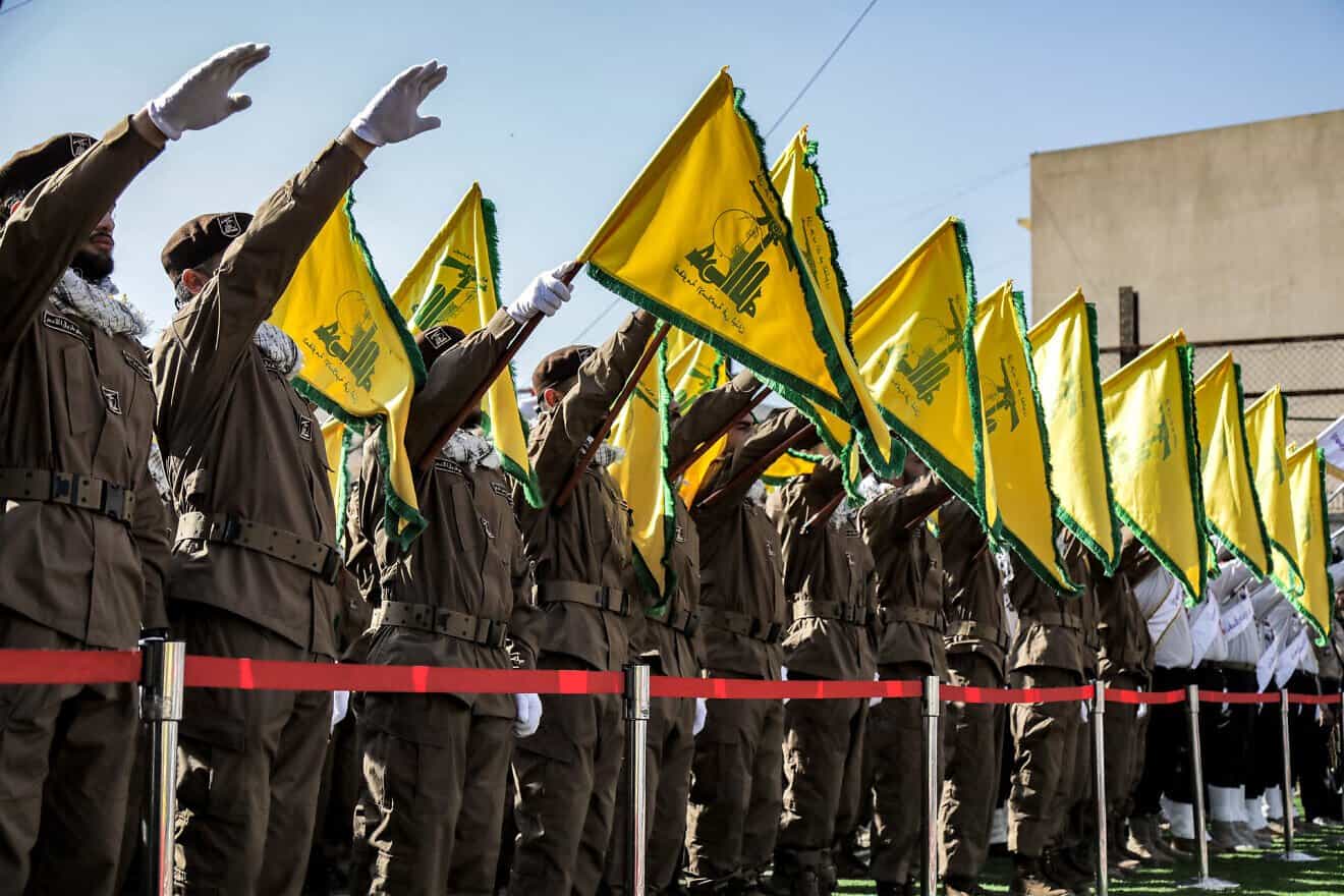 Hezbollah members salute and raise the group's flags during the funeral of their fallen comrades Ismail Baz and Mohamad Hussein Shohury, who were killed in an Israeli strike on their vehicles, in Shehabiya in south Lebanon on April 17, 2024. Photo by AFP via Getty Images.