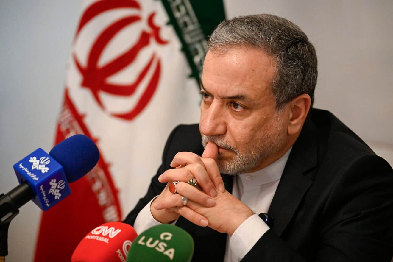Iranian Foreign Minister Abbas Araghchi sits by the Iranian flag as he talks to journalists at the Iranian Ambassador residency on Nov. 27, 2024 in Lisbon, Portugal. Photo by Horacio Villalobos#Corbis/Corbis via Getty Images.