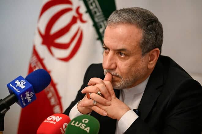 Iranian Foreign Minister Abbas Araghchi sits by the Iranian flag as he talks to journalists at the Iranian Ambassador residency on Nov. 27, 2024 in Lisbon, Portugal. Photo by Horacio Villalobos#Corbis/Corbis via Getty Images.