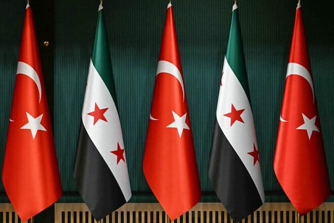The flag of Turkey and the recently adopted flag of the Syrian Arab Republic are seen before a press conference by the Turkish president and Syrian interim president, following their meeting at the Presidential Palace in Ankara, on Feb. 4, 2025. Photo by Ozan Kose/AFP via Getty Images.