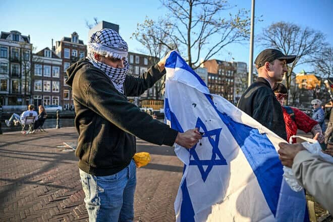 Pro-Palestinian activists attempt to burn an Israeli flag in Amsterdam, April 3, 2025. Photo by Mouneb Taim/Middle East Images/AFP via Getty Images.