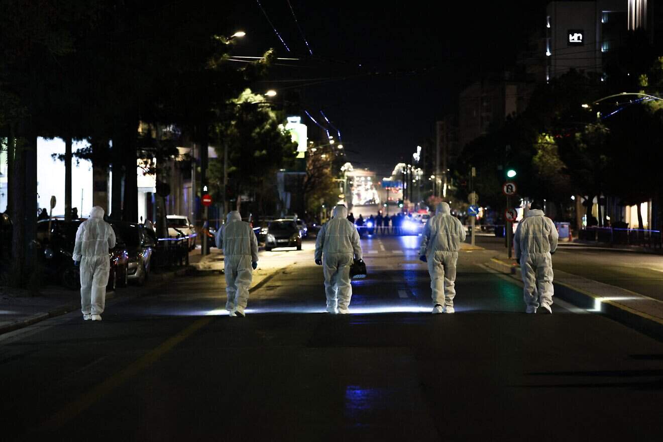 Members of the Greek police's counter-terrorism unit investigate the area outside the Hellenic Train offices in central Athens after a bombing, April 11, 2025. Photo by Aris OIkonomou/SOOC/AFP via Getty Images.