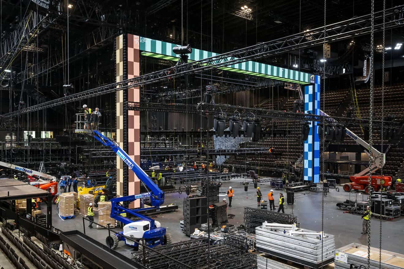 Employees work under an element of the stage during a press visit at the St. Jakobshalle multi-purpose indoor arena that will host the 2025 Eurovision Song Contest, in Basel, Switzerland, April 15, 2025. Photo by Fabrice Coffrini/AFP via Getty Images.