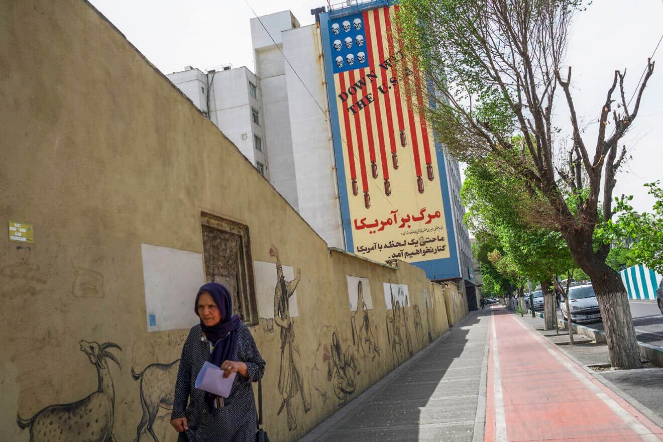 Iranians pass by the recently repainted, famous anti-American mural that depicts the U.S. flag with bombs and skulls in Tehran, Iran, on April 10, 2025. Photo by Mohammadali Najib/Middle East Images/AFP via Getty  Images.