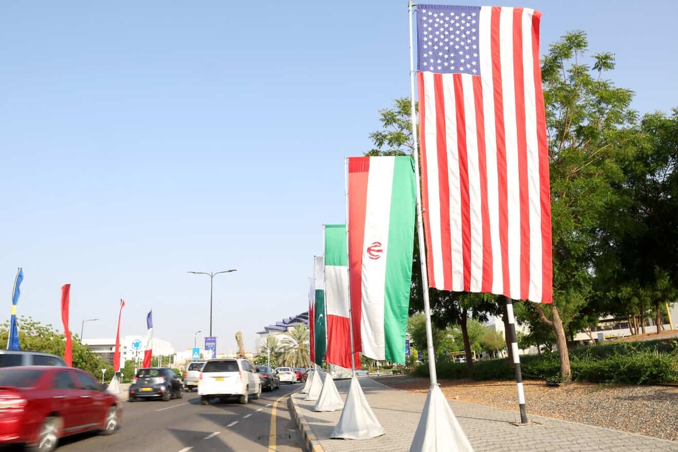 The flags of the United States and Iran hang on the road leading to the Muscat International Book Fair, on April 25, 2025. Photo by Haitham Al-Shukairi/AFP via Getty Images.