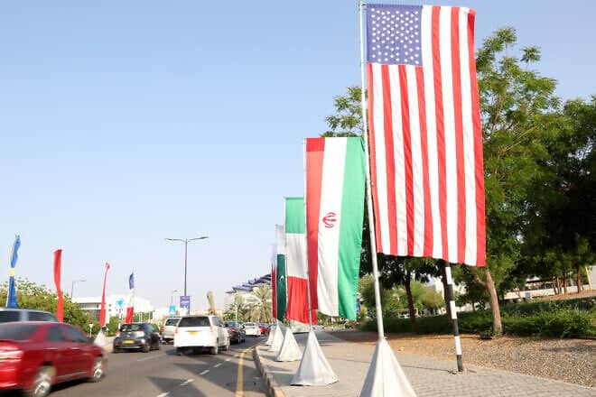 The flags of the United States and Iran hang on the road leading to the Muscat International Book Fair, on April 25, 2025. Photo by Haitham Al-Shukairi/AFP via Getty Images.
