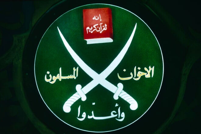 Emblem of the fundamentalist Islamic movement founded in 1928, Society of the Muslim Brothers, on display during a press conference in their Cairo office. Photo by Maher Attar/Sygma via Getty Images.