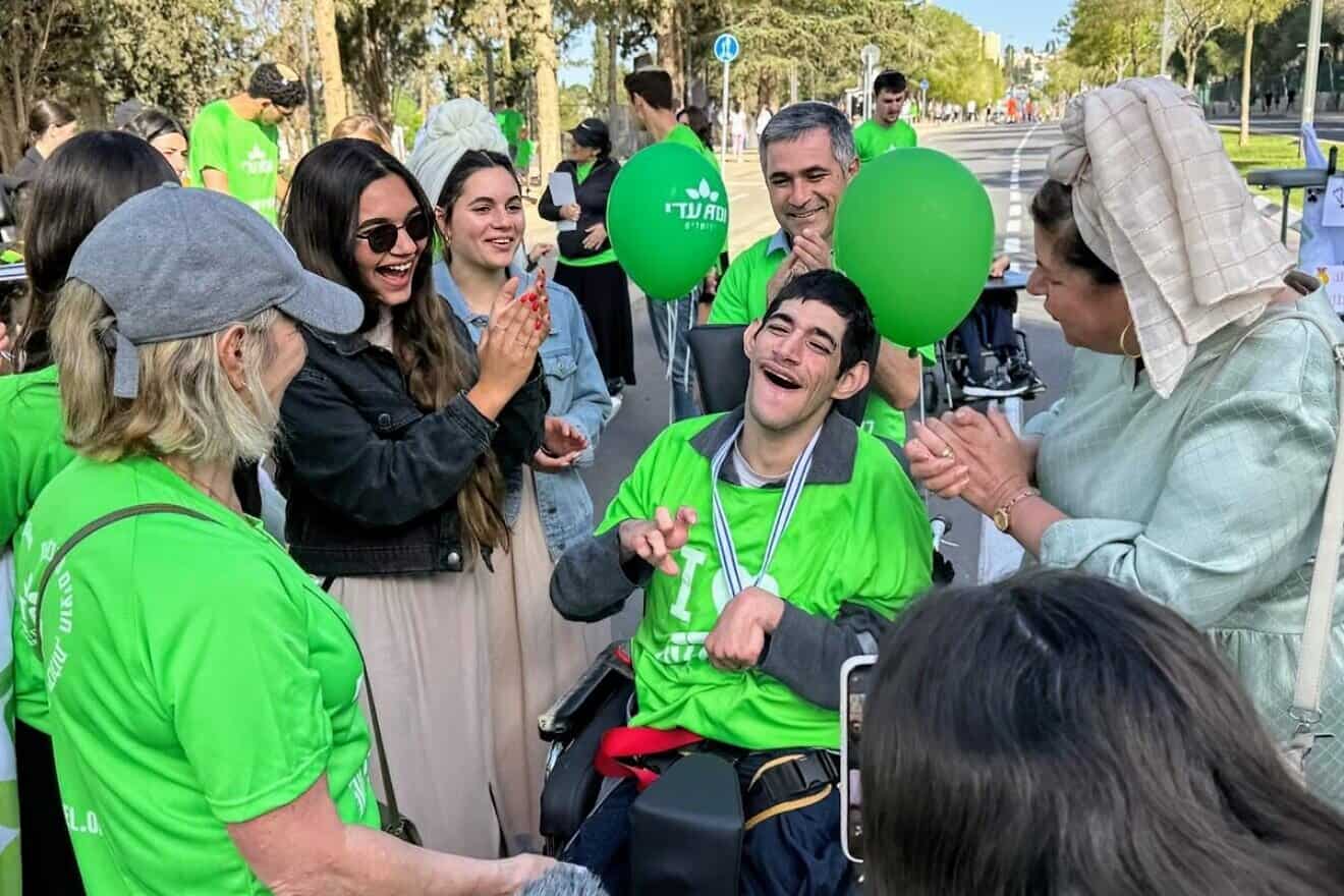 Surrounded by family and friends, an ADI resident receives a medal from ADI Jerusalem director Shlomit Grayevsky after completing the 800-meter Communities Track during the 2025 Jerusalem Marathon on April 4, 2025. Credit: Courtesy.