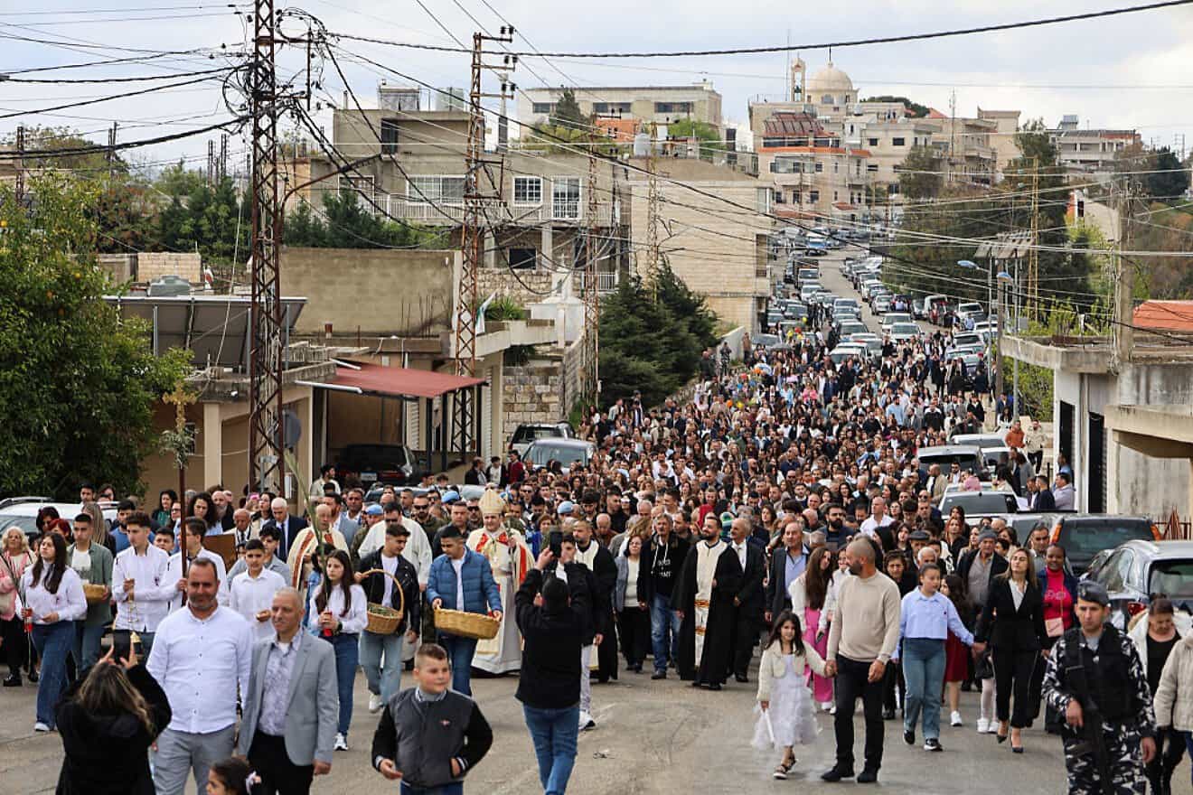 Residents and members of the clergy march together ahead of Palm Sunday mass in Lebanon's southern village of Qlayaa on April 13, 2025. Photo by Rabih Daher/AFP via Getty Images.
