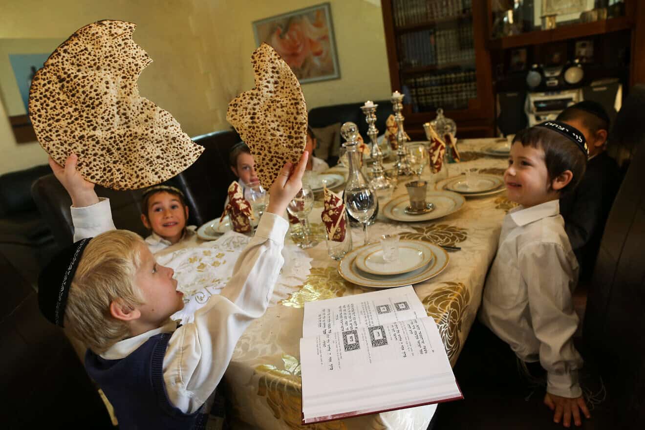 During a model Passover seder, a young boy breaks a matzah into two pieces during the traditional “yachatz” part of the ceremony. Photo by Nati Shohat/Flash90.
