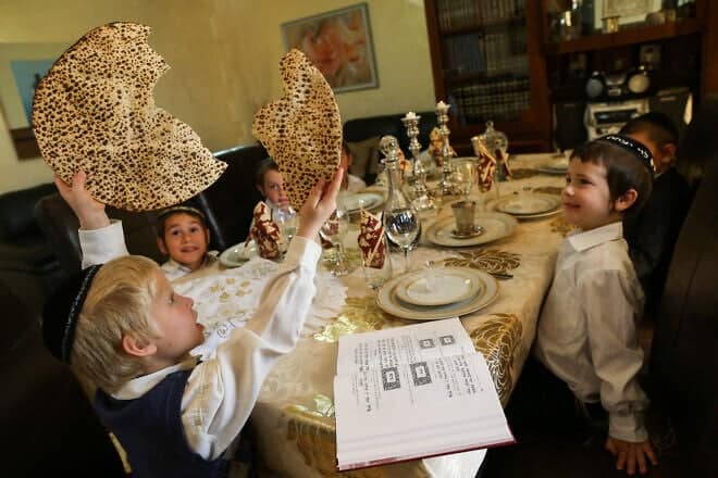 During a model Passover seder, a young boy breaks a matzah into two pieces during the traditional “yachatz” part of the ceremony. Photo by Nati Shohat/Flash90.