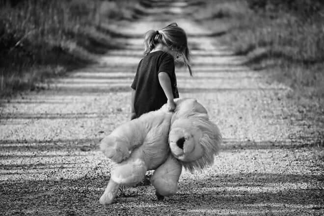A child walks down a dirt road with a stuffed animal. Credit: Pexels/Pixabay.