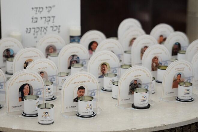 Memorial candles in front of images of the fallen at the OneFamily Passover weekend. Photo by Meir Pavlovsky.