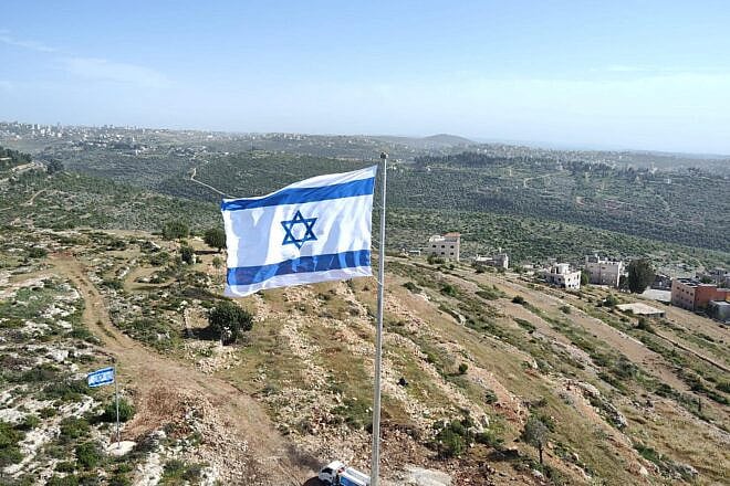 A massive Israeli flag, measuring almost 40 foot by 30 foot, near the village of Ateret in the Binyamin region of Samaria. Credit: Binyamin Regional Council.