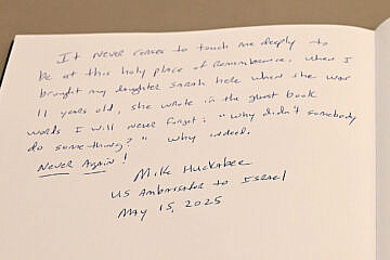 Mike Huckabee, the U.S. ambassador to Israel, signs a visitor book on a visit to Yad Vashem, May 15, 2025. Credit: U.S. embassy in Israel.