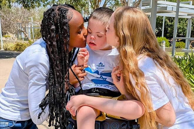 National Service volunteers at the ADI Negev-Nahalat Eran rehabilitation village dote on a special-education student with severe disabilities, 2025. Credit: Courtesy of ADI.
