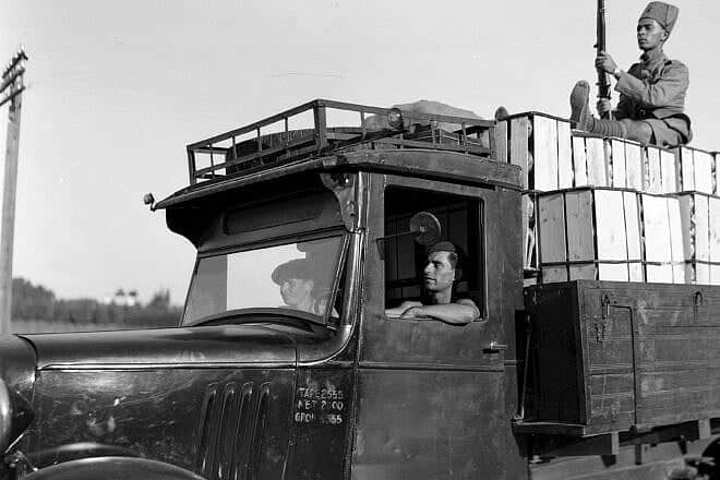 A guard from the Hagana accompanies a truck carrying oranges in pre-state Israel on Oct. 24, 1938. Credit: Zoltan Kluger and Israel National Photo Collection via Wikimedia Commons.
