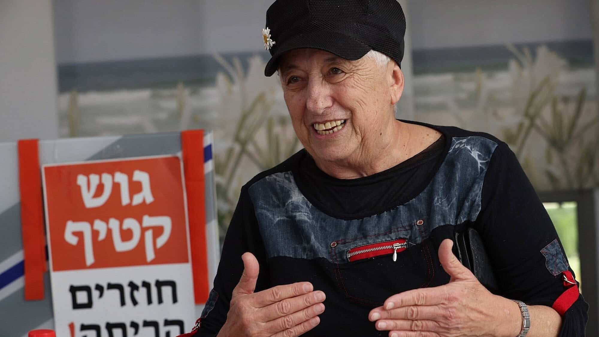 Anita Tucker surrounded by memories of Gush Katif, including an orange sign announcing a return “home.” Photo by Yossi Zamir.