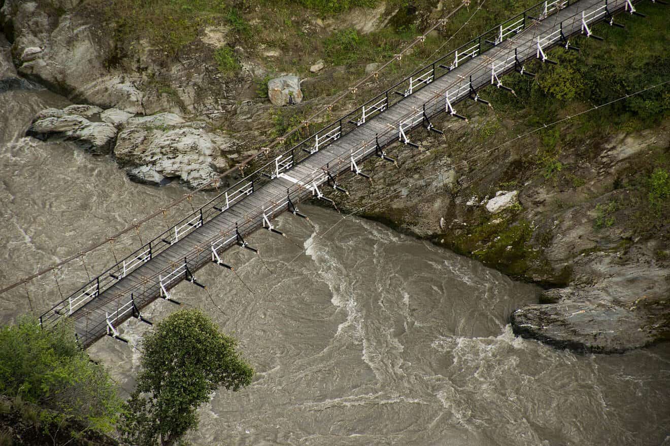 The border of the disputed Pakistan-occupied Kashmir and the Indian state of Jammu and Kashmir; a white border painted on a suspended bridge delineates Azad Kashmir from Jammu and Kashmir, 2015. Credit: Umar Jamshaid via Wikimedia Commons.