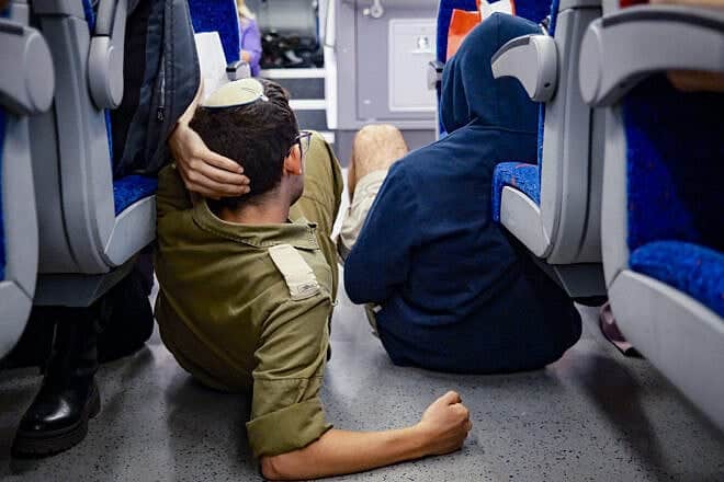 People take cover as siren warns of incoming missile fired from Yemen, on the train in Jerusalem, May 13, 2025. Photo by Dor Pazuelo/Flash90.