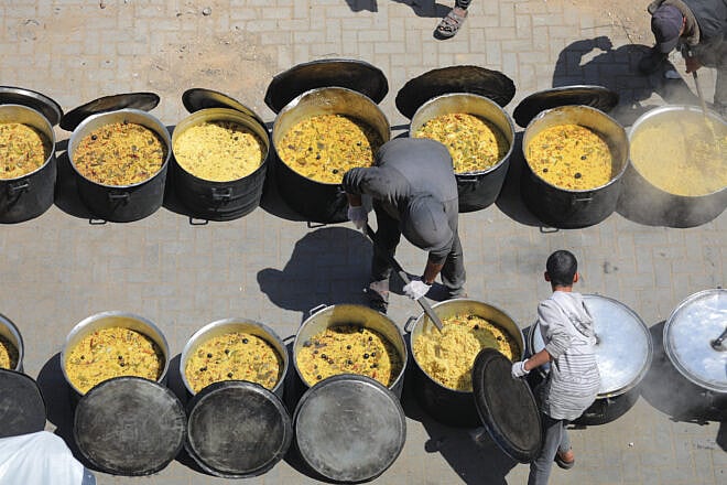 Charitable organizations distribute hot meals to Palestinians in the Nuseirat refugee camp in the Gaza Strip on April 18, 2025. Photo by Ali Hassan/Flash90