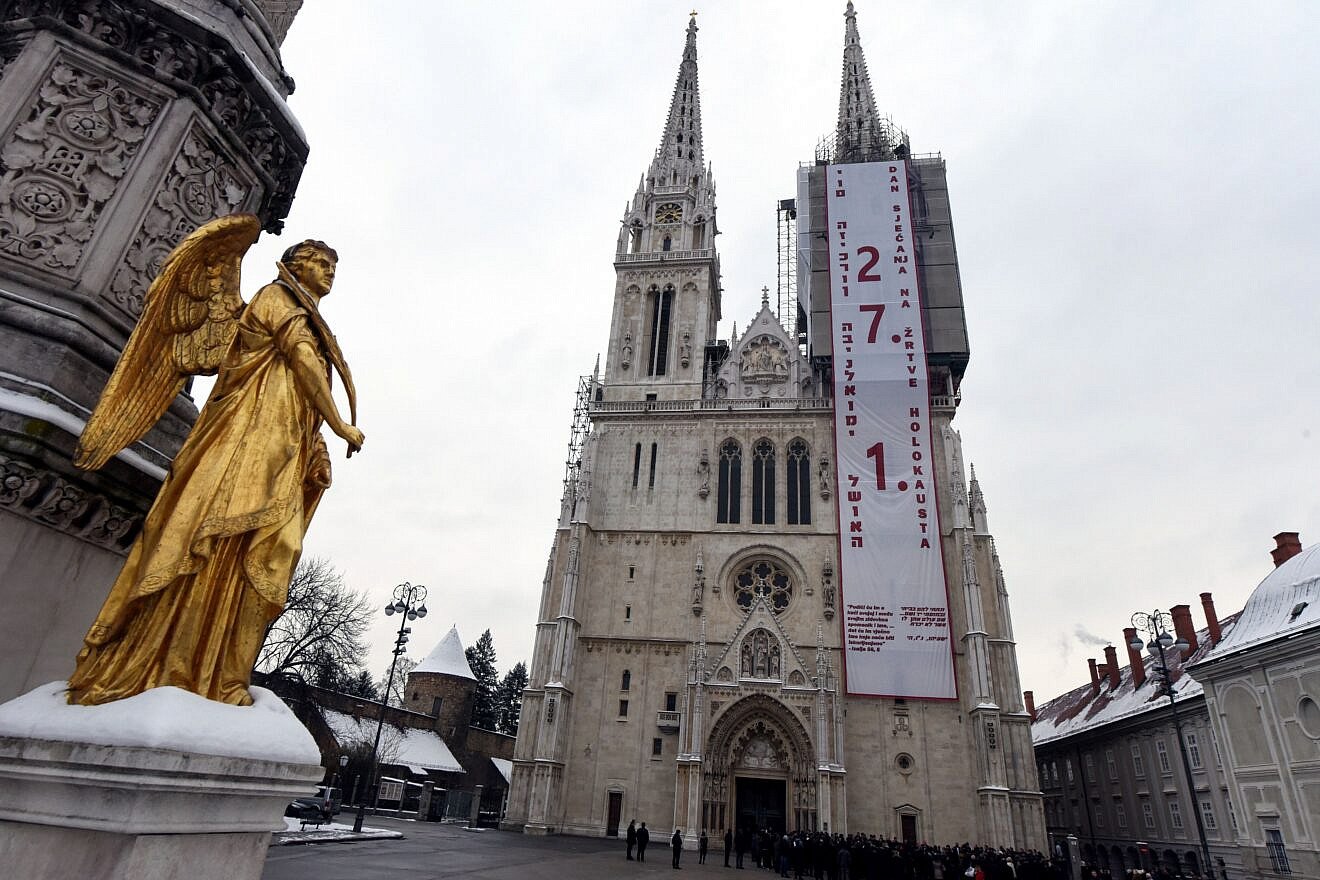 A banner states "Day of Remembrance for the Victims of the Holocaust" in Croatian and Hebrew on Zagreb's cathedral ahead of the International Holocaust Remembrance Day, Jan. 24, 2019. Photo by Denis Lovrovic/AFP via Getty Images.
