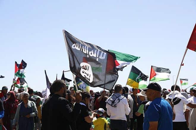 A man holds an ISIS flag as pro-Palestinian protesters gather in Cape Town on Nov. 12, 2023. Photo by Gianluigi Guercia/AFP via Getty Images.