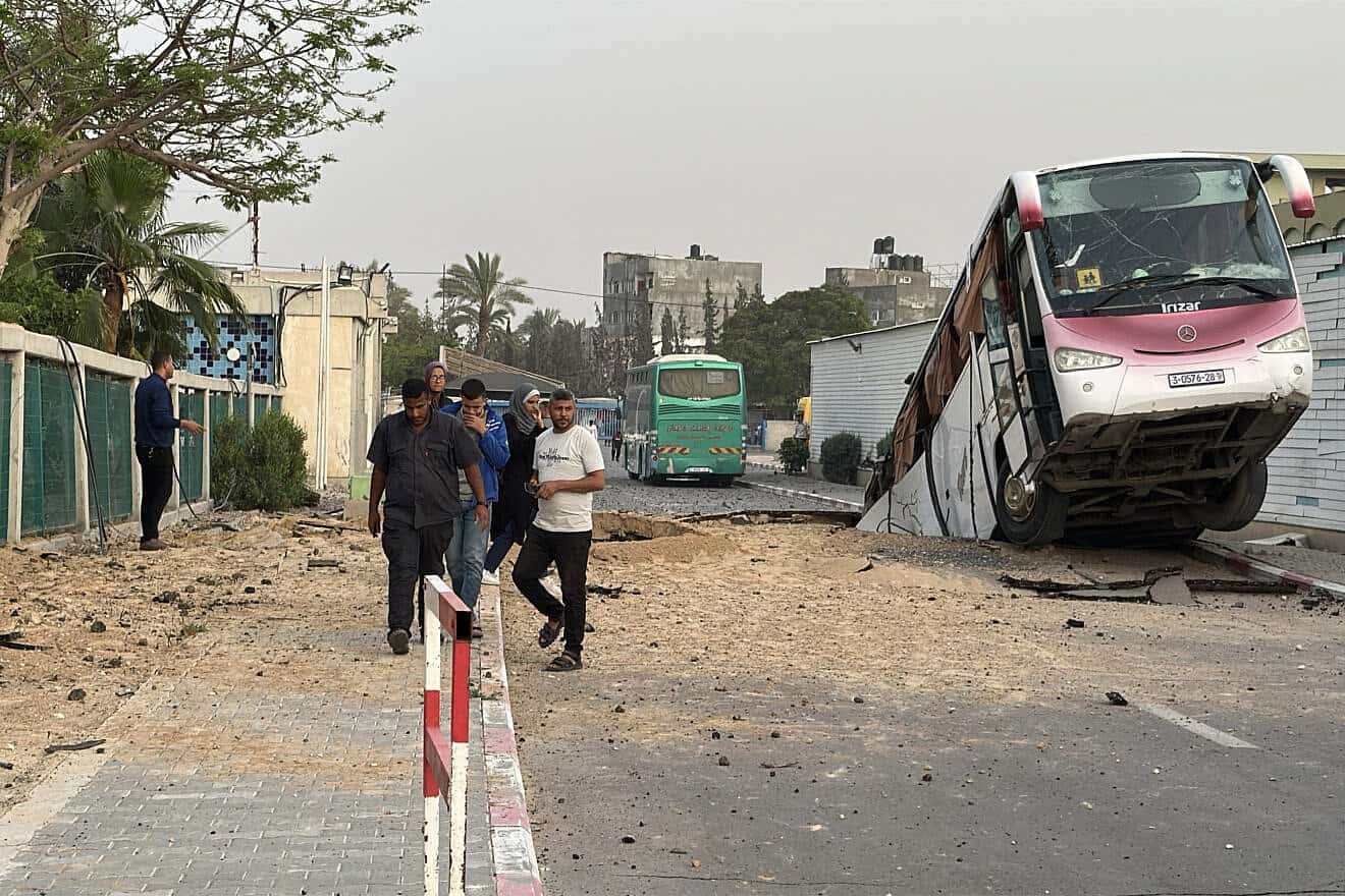A bus sits inside a crater following an Israeli strike in Khan Yunis in the southern Gaza Strip on May 13, 2025. Photo by AFP via Getty Images.