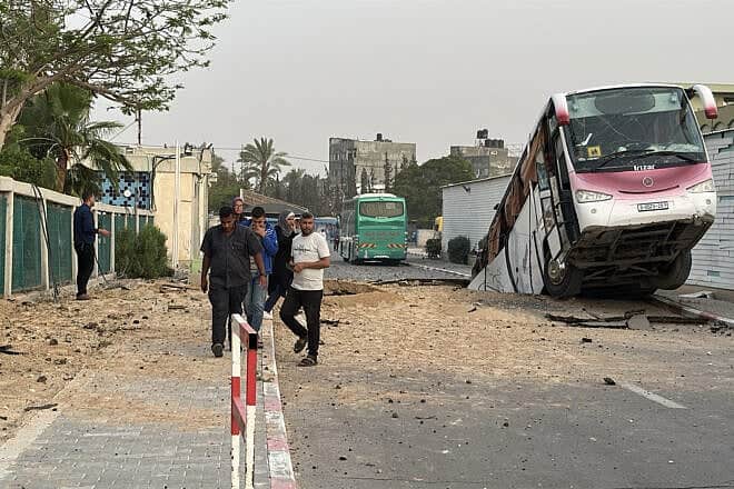A bus sits inside a crater following an Israeli strike in Khan Yunis in the southern Gaza Strip on May 13, 2025. Photo by AFP via Getty Images.
