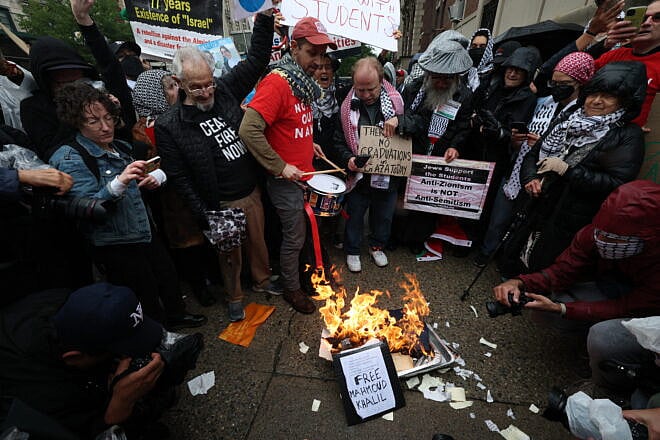 Antisemitic protesters burn diplomas as Columbia University and Barnard College students hold a graduation rally, May 21, 2025. Credit: Timothy A. Clary/AFP via Getty Images.