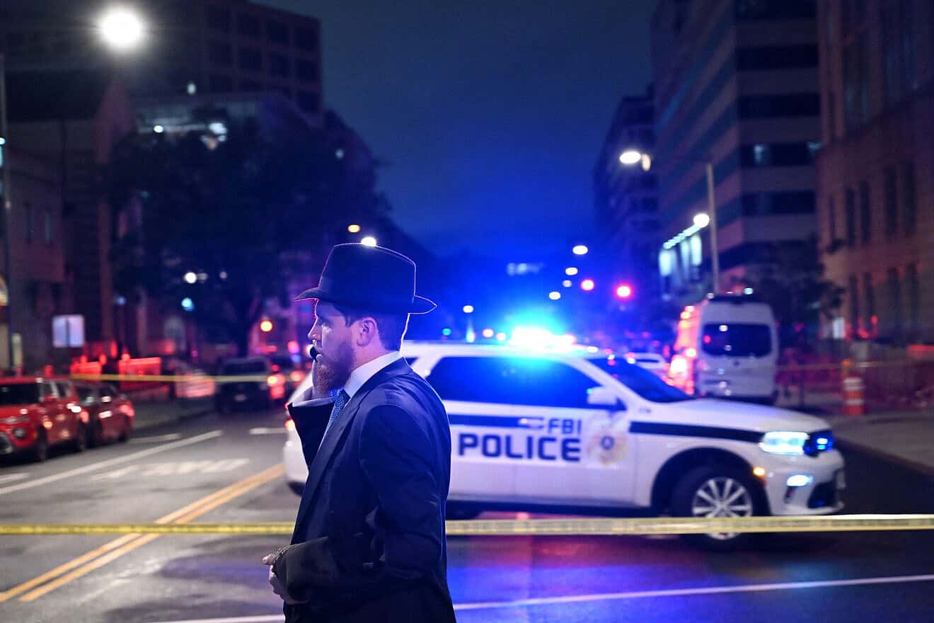 A man, standing behind police tape, talks on his cell phone outside the Capital Jewish Museum following a shooting that left two Israeli embassy staff members dead, in Washington, D.C., on May 21, 2025. Photo by Alex Wroblewski/AFP via Getty Images.