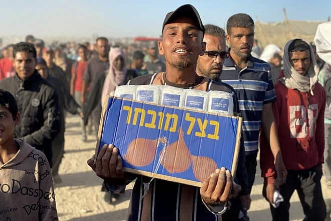 Displaced Palestinians carrying relief supplies return from aid distribution centers in Rafah to their tents in the southern Gaza Strip on May 29, 2025. Photo by AFP via Getty Images.