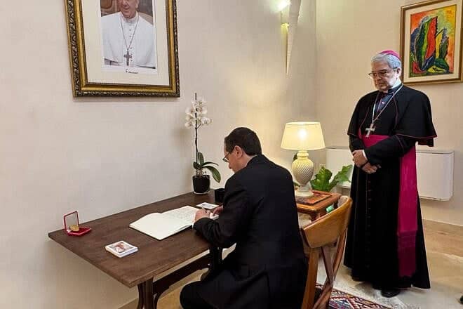 Israeli President Isaac Herzog signs the book of condolences at the Vatican's embassy in Tel Aviv as Apostolic Nuncio Adolfo Tito Camacho Yllana watches, May 2, 2025. Credit: President's Spokesperson.