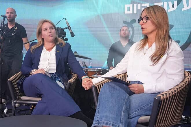 Tali Mishaelof (left), the bereaved mother of Sgt. Gal Mishaelof, and Adi Marciano, the bereaved mother of Cpl. Noa Marciano, share a moment on stage at OneFamily’s Yom Hazikaron ceremony on April 29, 2025. Photo by Meir Pavlovsky/OneFamily.