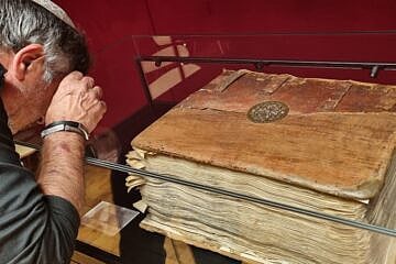 A visitor inspects Keter Yom Yakir, one of the 12 Damascus Crowns, on exhibition at the National Library of Israel. Photo by Sharon Altshul.
