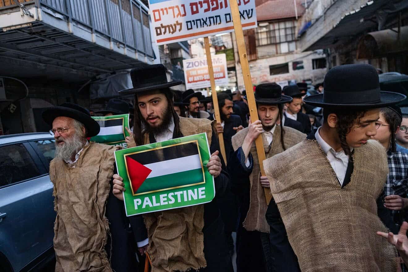 Ultra-Orthodox Jews belonging to the Neturei Karta sect in the Mea She'arim neighborhood of Jerusalem hold up signs as they protest the State of Israel during its 77th Independence Day, May 1, 2025. Photo by Chaim Goldberg/Flash90.