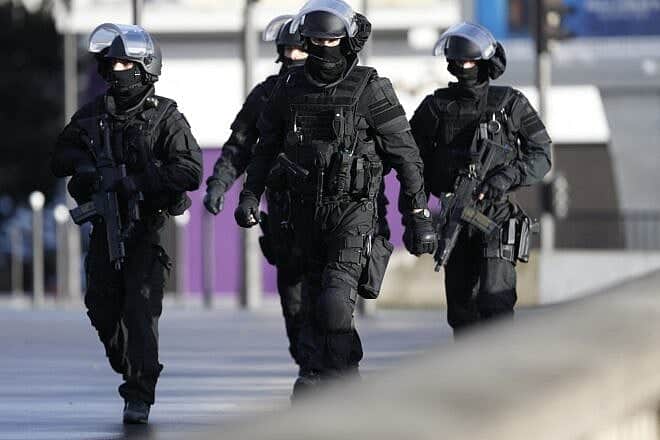 French police walk above the peripherique circular road in Porte de Vincennes, eastern Paris, to take their positions after a gunman opened fire and took people hostage at the Hyper Cacher kosher grocery store on Jan. 9, 2015. Photo by Thomas Samson/AFP via Getty Images.