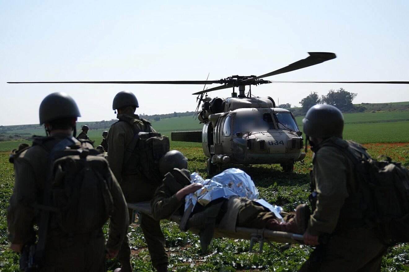 IDF medical corps troops evacuate a wounded colleague to a waiting helicopter. (Credit: Israel Defense Forces)